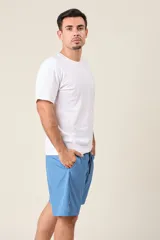 Bermuda deportiva de nylon color gris, de corte suelto, con cintura elástica y cordón de ajuste. Cuenta con detalles de líneas negras en los costados y bolsillos laterales con cierre.