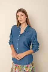 Camisa de denim azul con botones y mangas largas.