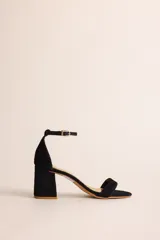 Sandalia de tacón cuadrado medio con tira delantera y pulsera ajustable al tobillo con hebilla metálica. Confeccionada en tela tipo terciopelo con forro y plantilla de cuero.