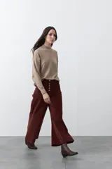 Pantalón de pana de corte wide leg, color marrón oscuro, con calce relajado y detalle de bordado en el borde de los bolsillos delanteros.