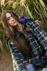 Buzo tipo canguro de corte oversize, confeccionado en paño de lana con diseño de rayas horizontales en tonos marrón, blanco y azul. Presenta una capucha amplia y un cuello de piel sintética en color verde oscuro.