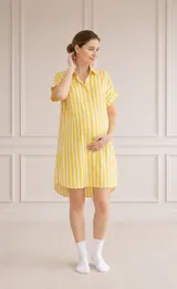 Camisa maternal de corte holgado y manga corta, confeccionada en viscosa suave con estampado de círculos azules sobre fondo blanco. Presenta cuello clásico y bolsillos frontales.