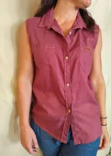 Camisa sin mangas color bordó, con cuello camisero, cierre frontal con botones y dos bolsillos plaqué en el pecho.