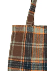 Bolso tipo tote bag con patrón de cuadros tartán en tonos marrón, naranja y negro, con doble asa superior.