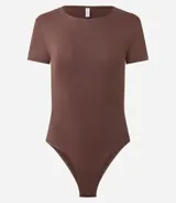 Body de cuello redondo y manga corta, confeccionado en tejido de poliamida con elastano. Presenta un diseño liso y ajustado al cuerpo con cierre en la entrepierna.