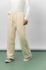 Pantalón deportivo de corte wide leg con caída relajada. Presenta cintura elastizada con cordón ajustable, bolsillos laterales y un interior frizado para mayor abrigo.