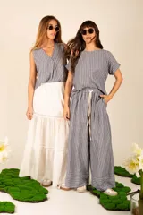 Falda larga blanca de corte amplio, con cintura elastizada y detalle de puntilla en el ruedo.