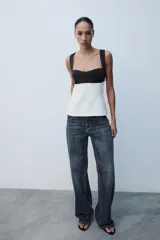 Top de escote cuadrado y tirantes anchos, con diseño bicolor en negro en la parte superior y blanco en el cuerpo, corte ligeramente acampanado y espalda descubierta con lazada.