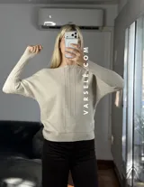 Sweater de punto con cuello redondo y mangas largas, con diseño de textura acanalada en los laterales y mangas. Presenta un corte holgado y cómodo.