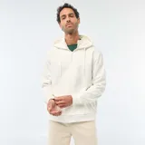 Buzo de felpa color blanco crudo, con capucha ajustable mediante cordones, cierre frontal parcial en el cuello y bolsillo tipo canguro. Presenta puños y ruedo acanalados.