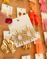 Par de caravanas doradas con forma de sol.