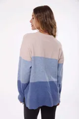 Buzo celeste de tejido de punto con bloques de color en celeste, azul y beige.