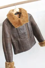 Campera de cuero genuino marrón con interior y detalles de piel sintética en cuello y puños, con cierre frontal y bolsillos.