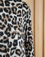 Remera de manga larga color marrón chocolate, con cuello redondo y dos bolsillos frontales tipo parche.