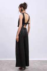 Pantalón marrón de corte palazzo, tiro alto, con pliegues frontales y pespuntes blancos decorativos.