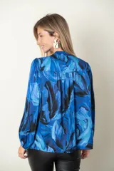 Blusa estampada en tonos de azul, de seda y viscosa, con escote en V y mangas largas terminadas en puño elástico.