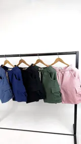 Bermuda rosa de algodón con textura waffle, corte recto, cintura elástica con cordón ajustable y bolsillos cargo laterales.