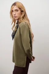 Sweater de tejido de punto color beige, con escote en V y mangas largas. Presenta un diseño básico y versátil de corte recto.