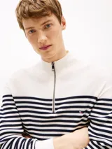 Sweater de punto texturizado a rayas horizontales blancas y azul marino, con cuello alto y cierre de cremallera metálica.