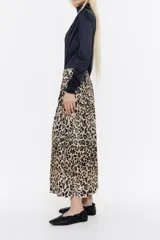 Falda larga con vuelo de viscosa con estampado animal print. Modelo de corte línea A, cierre de cremallera lateral invisible, y cadera ajustable con pestaña y cordones de tejido.
