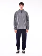 Buzo de polar color verde oliva, con cuello alto y cierre frontal parcial. Presenta puños y cintura acanalados.