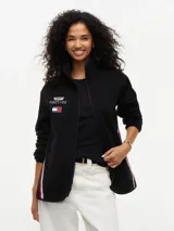 Campera de tejido polar negra Tommy Hilfiger, con cuello chimenea y cierre de cremallera. Presenta diseño Global Stripe en los laterales, bolsillos abiertos en diagonal y el logo de la marca junto con el de Cadillac Formula 1 Team en el pecho.