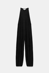 Mono largo de lyocell color negro, con cuello halter, cierre lateral con cremallera oculta y botones en el cuello. Presenta un diseño holgado con bajo acabado en puño elástico.