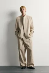 Blazer de corte relaxed fit confeccionado en tejido de lino y algodón de origen italiano. Presenta cuello mao, cierre cruzado con botones, bolsillos de vivo en la cadera y manga larga.