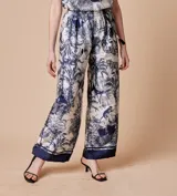 Pantalón palazzo estampado en tonos blanco y azul, con cintura elastizada y cordón ajustable.