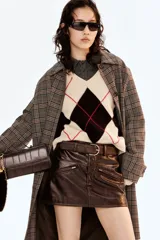 Sweater corto de punto jacquard con diseño de rombos en colores negro, beige y líneas rojas. Presenta escote en V, mangas largas y terminaciones acanaladas en cuello, puños y ruedo.