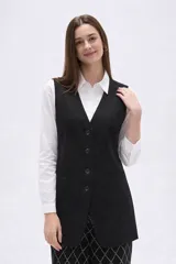Chaleco largo de corte sastrero en color negro, con escote en V, cierre frontal de botones y bolsillos laterales simulados.