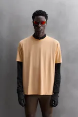 Camiseta deportiva color naranja confeccionada en tejido técnico, ligero y elástico. Tiene cuello redondo, mangas cortas y logo estampado.