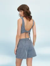 Short de tiro alto con estampado de rayas verticales finas en azul marino y blanco. Presenta un lazo a juego en la cintura y un corte holgado.