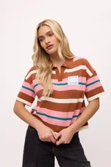 Remera tejida de algodón con cuello polo amarillo, corte boxy y estampado de rayas horizontales en tonos azul claro, marrón, rojo y amarillo.