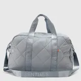 Bolso deportivo tipo duffel con diseño acolchado de rombos en color gris. Cuenta con asas de mano y correa de hombro ajustable, ambas con la inscripción Bubba Essentials. Incluye cierre principal y detalles metálicos.