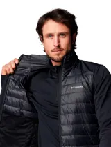 Chaqueta híbrida Columbia con panel frontal acolchado y mangas de tejido softshell liso. Cuenta con cierre frontal completo, cuello alto y tecnología Omni-Shield para repelencia a la humedad y manchas.