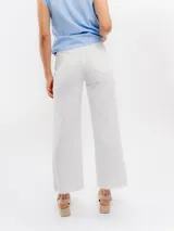 Jean de tiro alto y pierna ancha, color blanco, con diseño de corte recto y ruedo deshilachado.