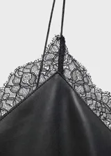 Vestido corto estilo lencero de efecto piel color negro, con escote en V y detalle de encaje en el borde. Posee tirantes finos y un diseño de corte recto.