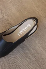Sandalia de taco corrido confeccionada en 100% cuero vacuno, color beige. Cuenta con capellada envolvente con recorte lateral elástico y tira trasera para mayor sujeción.