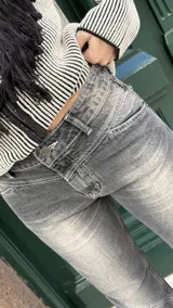 Jean de corte recto y tiro medio, color rosado con efecto acid wash y costuras diagonales en negro.