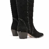 Bota alta de gamuza negra con caña alta, punta afinada, taco bajo ancho y costuras decorativas artesanales a lo largo de la silueta. Cuenta con cierre lateral.