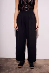 Pantalón negro de corte amplio, con cintura elástica y textura arrugada.