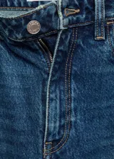 Jeans de tiro alto con corte mom-fit, confeccionados en tejido de algodón estilo vaquero. Presentan cierre de cremallera con botón, trabillas para cinturón y diseño clásico de cinco bolsillos.