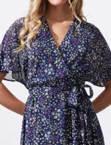 Vestido largo con estampado floral multicolor, escote en V cruzado, cintura elastizada con lazo de ajuste y forro interno. Marca Sandra Darren.