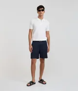 Remera polo slim de Marfinno confeccionada en viscosa texturizada de color blanco, con cuello polo y cierre frontal de cremallera corta, de manga corta.