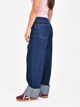 Jean de mujer color azul oscuro, de corte recto y tiro alto, con costuras verticales decorativas en la parte delantera de las piernas. Presenta dobladillo ancho en los tobillos.