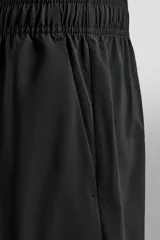Pantalones deportivos cortos de tejido técnico ligero y elástico, con cintura elástica ajustable, bolsillos frontales y aberturas laterales en el bajo.