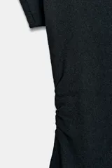 Vestido largo de punto color negro, con cuello barco, manga corta y frunces laterales en la cintura.