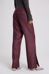 Pantalón de vestir marrón con textura, tiro bajo, bolsillos delanteros con labio y cierre metálico oculto, bolsillo sastrero en espalda, pierna con recortes en delantero y pinza en espalda.