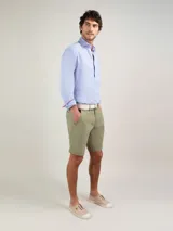 Bermuda de hombre de corte regular fit, color verde militar, confeccionada en mezcla de algodón y elastano. Cuenta con bolsillos laterales y bolsillos traseros.